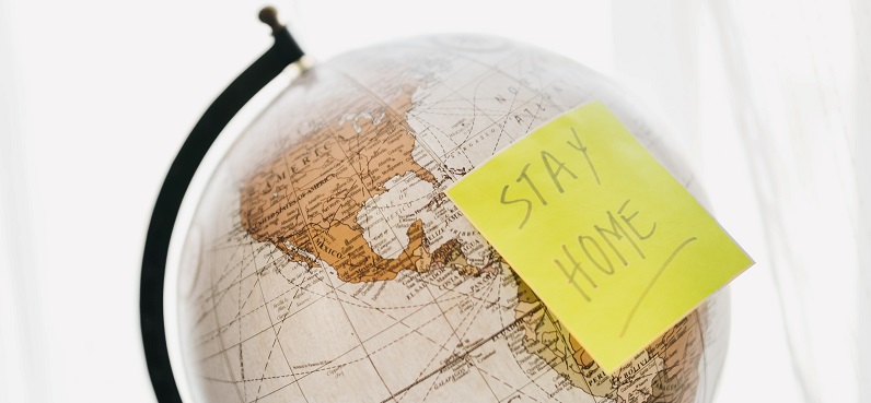 Stay home note on a globe